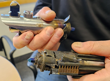 A person holding a metal object  AI-generated content may be incorrect.
