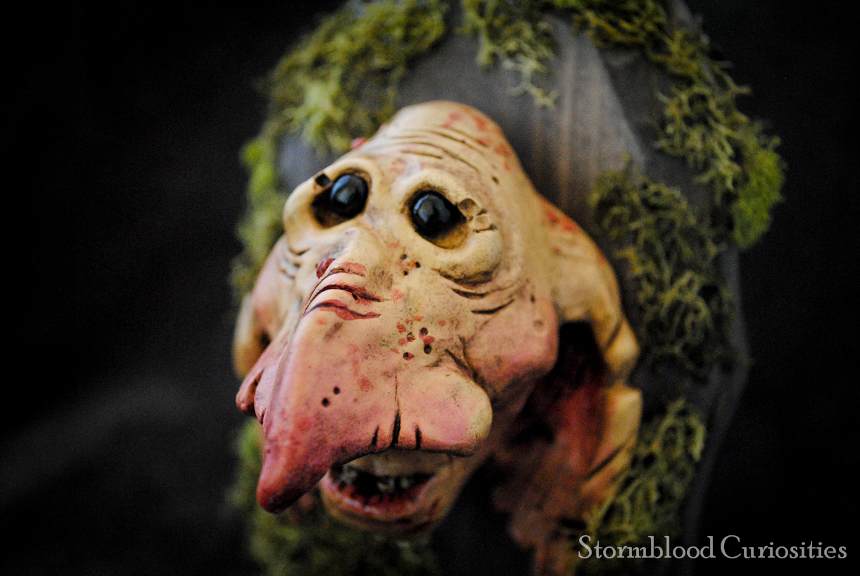 A plaster-cast "Goblin Minion" head on stained Pine and dired moss.