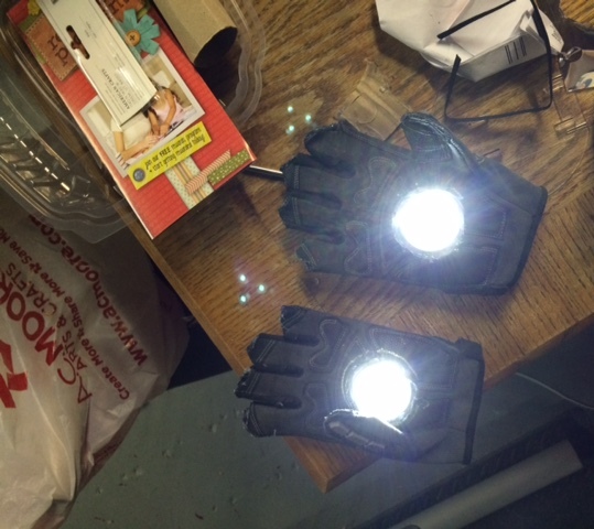 cut tops off my old work glove, hot glued the holes together so they'd fit kid better, cut holes out in center of gloves, used push lights from target