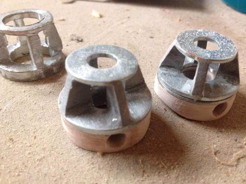 Finished light cages with the failed metal casting in the background. The cages are two washers connected by plastic webs, glued with 5 min epoxy, the