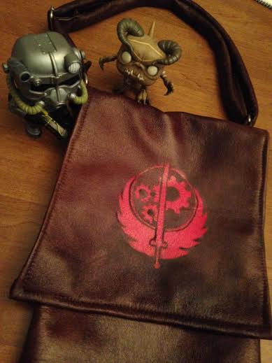 I made a bag to carry my things around in during cons. Made of faux leather, with a black inner lining and an adjustable strap. Spray painted the BoS