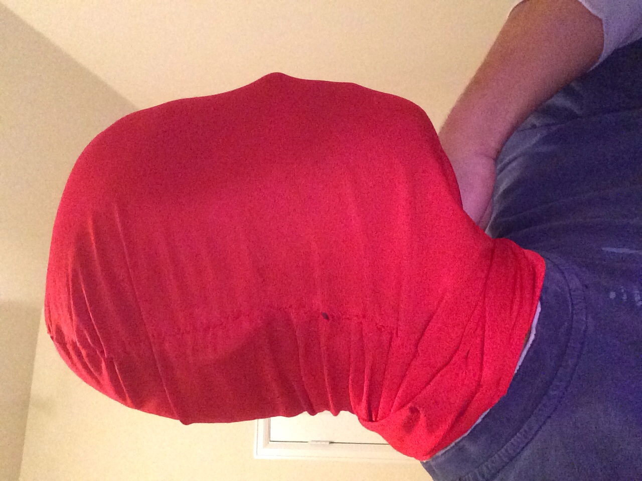 Profile view of mask, hand is holding excess fabric to kind of make it look like a mask.