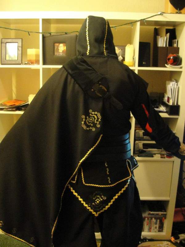 Rear view.
Cape, fur trim, gold transfer detailing.