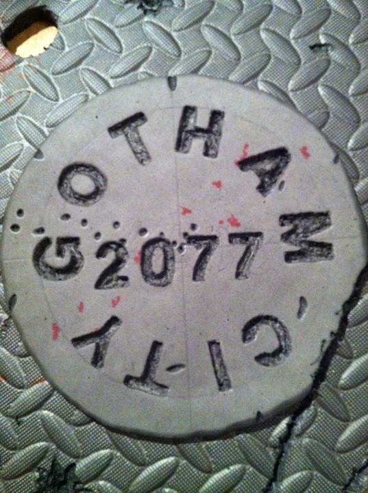 Shield Commission.

My buddy wanted the city to be Gotham for the manhole cover to pay homage to one of his favorite cosplays, The Joker. I suggeste